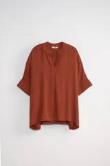 Blusa color terracota con escote en V y mangas cortas.
