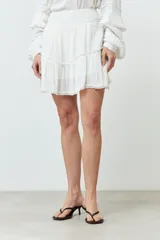 Minifalda blanca de bambula con volados y cintura elastizada.