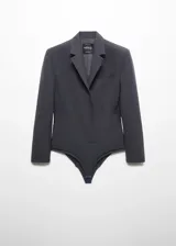 Americana entallada color gris oscuro, con solapas de muesca, manga larga con puños abotonados, bolsillo de ribete en el pecho, forro interior y cierre frontal con botones. Diseño body.