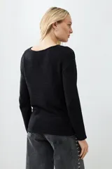 Sweater negro de tejido de punto con calado en la parte superior delantera y en los hombros.