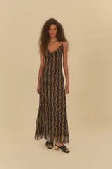 Vestido largo negro con estampado de cadenas doradas y detalles florales. Tiene tirantes finos y escote en V.