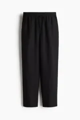 Pantalón tobillero negro de corte holgado en tejido liviano de mezcla de lino. Modelo de tiro alto con elástico revestido y cordón para ajustar fino en la cintura, bolsillos al bies y piernas ajustadas.