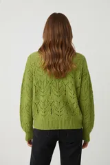 Sweater de punto color crudo, con cuello redondo y tejido calado con diseño de hojas o espigas.