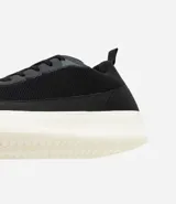 Championes Viko de hombre, color negro con suela blanca, confeccionados en poliéster con recortes y suela de EVA. Diseño casual y confortable.