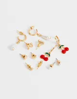 Set de seis pares de aros dorados con diferentes diseños: perlas, moños, corazones, bolitas y cerezas.