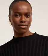 Suéter negro de punto con cuello redondo y mangas largas. Presenta rayas verticales texturizadas y tejido con hilos metalizados.