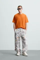 Camiseta color arena de algodón compacto, corte recto, cuello redondo y mangas cortas.