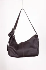 Cartera bandolera color marrón, de diseño descontracturado con correa regulable y cierre metálico.