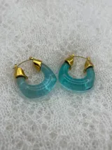 Par de aros tipo argolla de acrílico color celeste con detalles dorados.