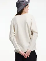 Sweater de punto color crema con escote en V y mangas largas.