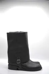 Bota de cuero color marrón oscuro con efecto desgastado, caña media, hebilla lateral y suela plana.