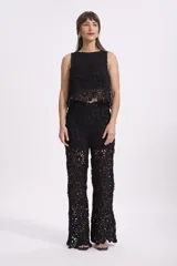 Pantalón negro de crochet con diseño floral calado y corte palazzo.