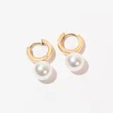 Aros tipo argolla dorados con dije colgante de perla blanca.