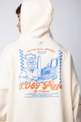 Buzo canguro amarillo ocre oversize de algodón rústico con capucha, cordones negros con letras blancas, bolsillo frontal y puños y cintura acanalados. Presenta estampados en el frente y las mangas.