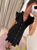 Vestido midi blanco con escote en V, abotonado al frente, mangas cortas con volados y falda evasé.