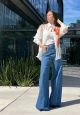 Pantalón de jean celeste de corte palazzo, tiro alto y bolsillos delanteros y traseros.