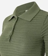 Blusa de punto color crema, con cuello polo, mangas cortas y puños con botones.
