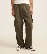 Pantalón paper touch color verde militar, con bolsillos laterales, cintura elástica y cordón de ajuste. Se convierte en bermuda gracias a un cierre a la altura de la rodilla.