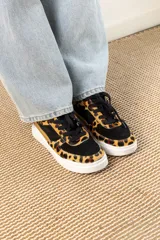 Championes negros con estampado animal print en tonos marrones y dorados.
