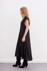 Vestido largo negro de viscosa jacquard con mangas cortas con detalle de tablas y ojalillos metálicos en mangas y escote.