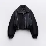 Campera bomber negra con cuello alto de punto acanalado, cierre frontal con cremallera, mangas largas abullonadas y bolsillos laterales con cremallera.