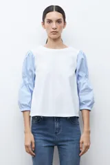 Remera de manga corta con cuerpo blanco liso y mangas largas abullonadas de tela a rayas celestes y blancas.