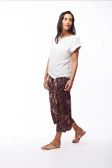 Blusa blanca de poliéster con cierre dorado en el escote y mangas cortas.