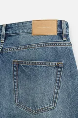 Pantalón de jean celeste de corte recto, con cinco bolsillos, efecto lavado y cierre frontal con botones.
