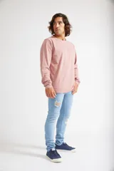 Jean skinny de hombre color negro, ajustado desde la cadera hasta los tobillos, con roturas en las rodillas y logo bordado en el bolsillo trasero.