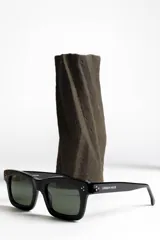 Lentes de sol negros con marco rectangular y lentes verdes.