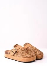 Zuecos color camel con plataforma, detalle de tachas y hebilla dorada.