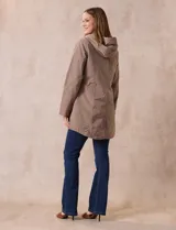 Campera impermeable color beige, marca Weatherproof, con capucha desmontable, cierre central oculto con botones a presión, bolsillos laterales con cierre y corte a la altura de la cadera.