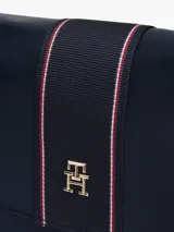 Cartera de hombro Tommy Hilfiger color azul marino, con correa de hombro y correa bandolera extraíble. Presenta una franja vertical con el logo de la marca en el centro.