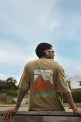 Remera gris con efecto gastado, de manga corta y corte holgado. Estampa en el pecho con un sol, una ola y la frase 'Life is Better'.