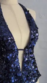 Top halter con espalda descubierta, confeccionado en tela con lentejuelas azules y forro interior.