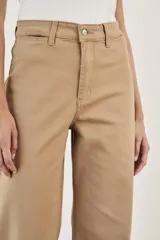 Pantalón wide leg color beige, de tiro alto, ligeramente ajustado en cintura y con ruedo desflecado.