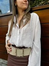 Camisa rosada de mangas largas con detalles de encaje en el frente.