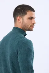 Buzo tejido color beige con textura, cuello alto con botones y manga larga.