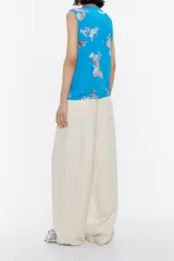 Top sin mangas con estampado de olas en tonos azules, corte recto, escote en V pronunciado y cordones ajustables.