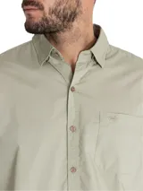 Camisa blanca de manga larga para hombre, confeccionada en algodón orgánico. Cuenta con cuello camisero, cierre con botones de madera, bolsillo en el pecho y mangas ajustables con botones.