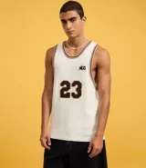 Musculosa de punto color crema con cuello redondo y bies contrastante en marrón. Presenta el número 23 estampado en el frente y un pequeño logo con una estrella.