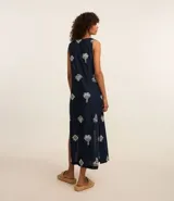Salida de playa tipo bata larga sin mangas, color azul marino, con bordado laise de caracolas y lazo delantero. Confeccionada en algodón BCI.