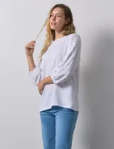 Blusa blanca texturada marca Ruby Rd, con escote redondo y mangas 3/4 con puño elastizado y apliques de broderie. Confeccionada en poliéster y elastano.