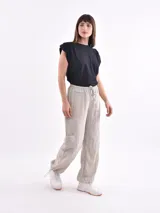 Pantalón marrón de corte ancho, con cintura elástica ajustable con cordón, bolsillos laterales y bolsillos tipo cargo en los muslos.