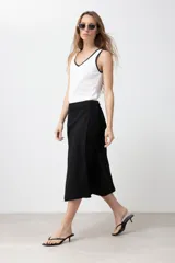Falda midi cruzada color negro, confeccionada en lino.
