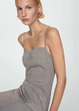 Vestido corto gris con estampado de cuadros, escote corazón y tirantes finos.