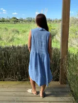 Vestido camisero azul sin mangas de lino italiano, con botones de nácar y corte a la rodilla.