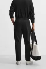 Pantalón de jogging color beige confeccionado en tejido de mezcla de algodón. Cuenta con cintura elástica ajustable con cordón, bolsillos frontales y traseros.