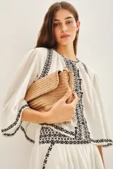 Camisa blanca de algodón con bordado negro en el ruedo, corte amplio y largo corto. Escote redondo y mangas largas abullonadas.