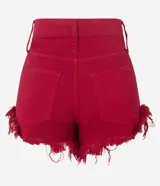 Short de jean color rojo con corte hot pants, tiro alto, bolsillos delanteros y traseros, y bajo desflecado.